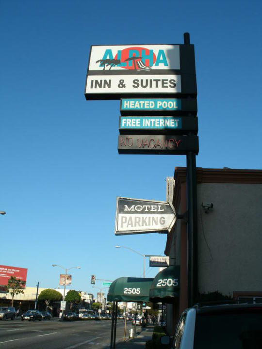 Schild an Straße Hotel Alpha Inn & Suites