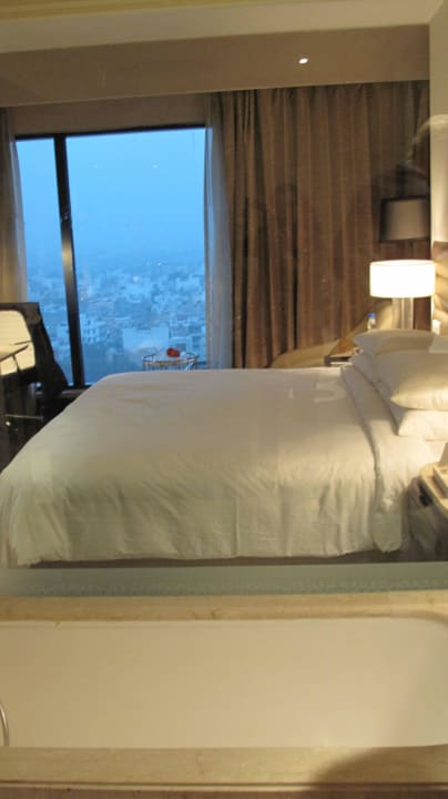 Bett und Blick zur Straße The Leela Ambience Convention Hotel Delhi