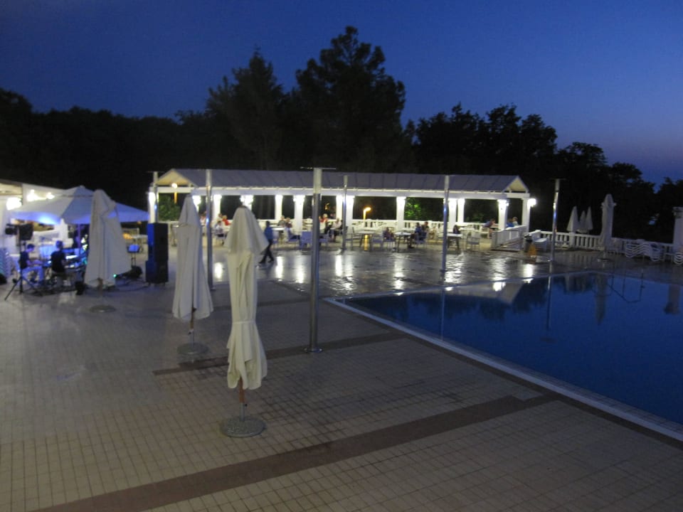 Hotelpool mit der Aktionsbühne am Abend Maistra Select Funtana All Inclusive Resort