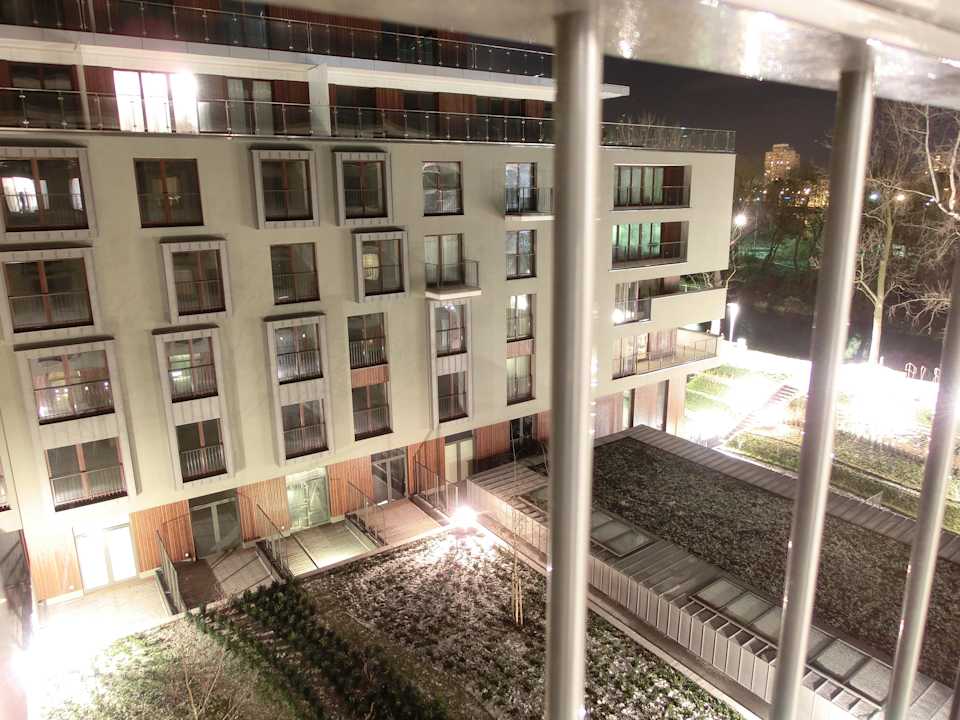 Nachts dezent illuminierter, grüner Innenhof Art Apart Premium