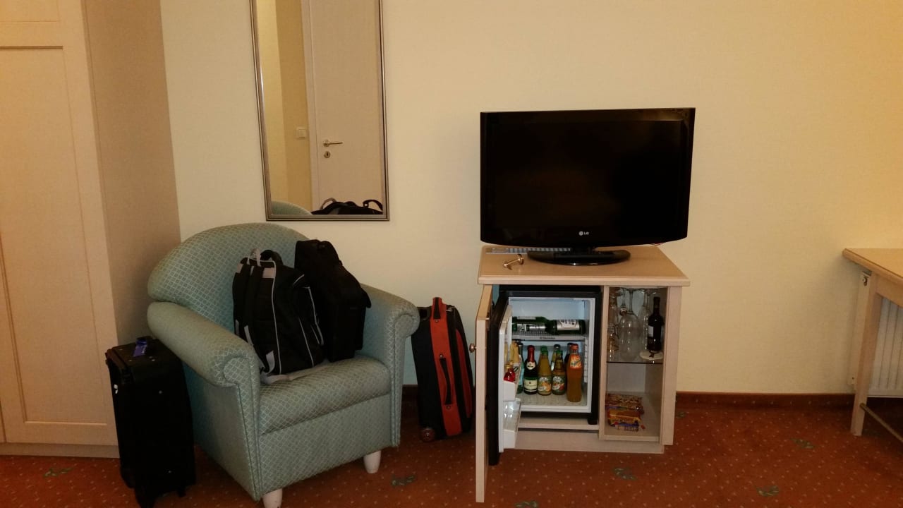 Minibar mit Flat-TV und Polsersessel Hotel Ampervilla