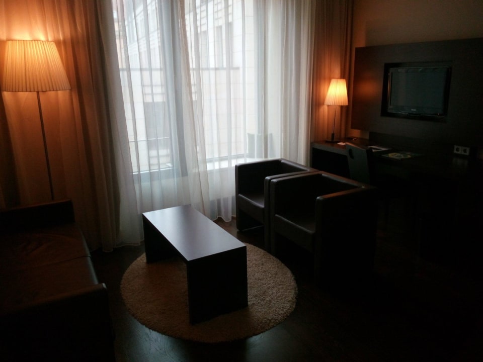 Sitzecke mit TV und Schreibtisch im Wohnbereich NH Collection Dresden Altmarkt