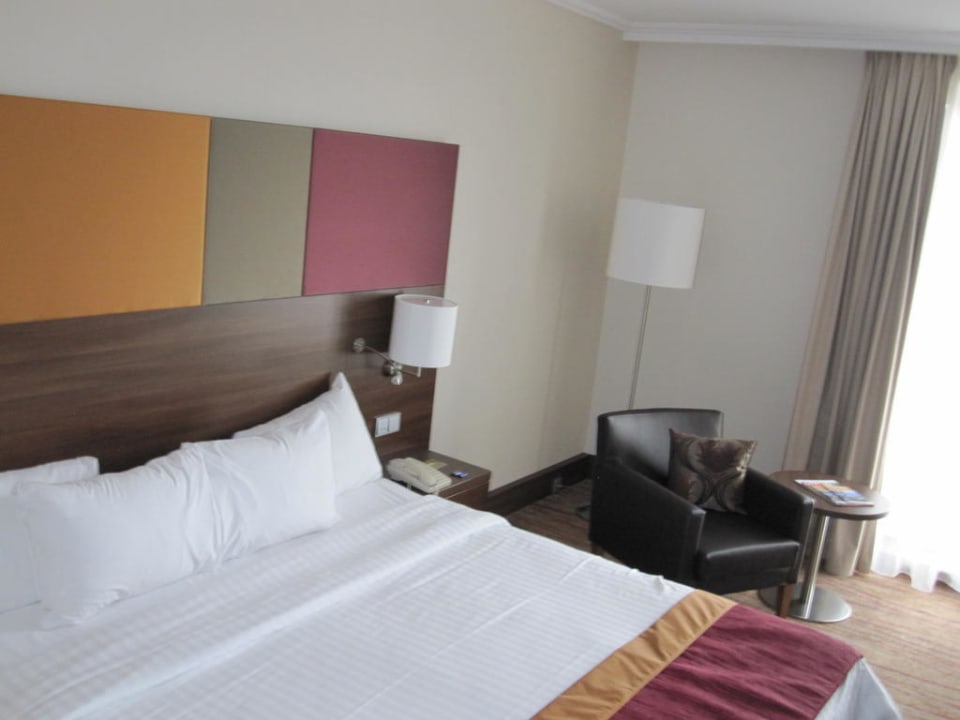 Bett mit Ledersessel im Hintergrund Hotel Courtyard by Marriott Linz