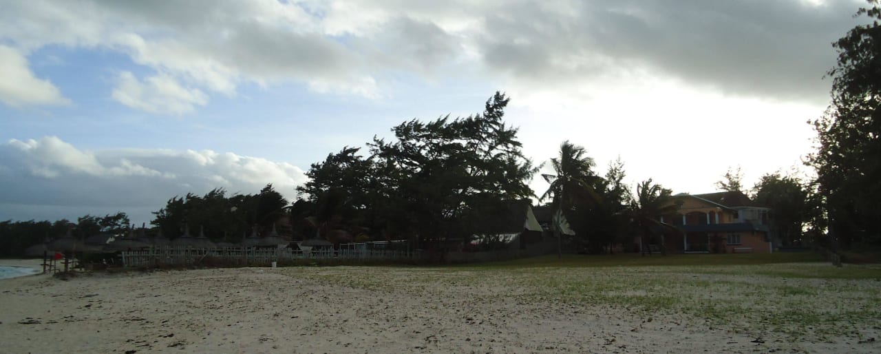 Links hinter dem Zaun die Hotelanlage Friday Attitude