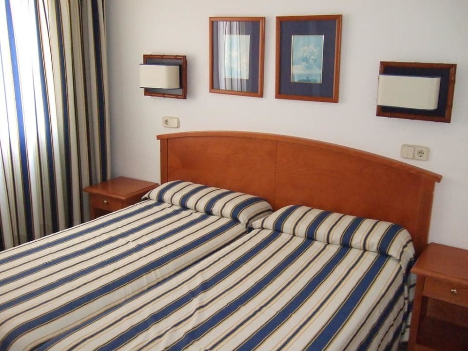 Bett im Schlafzimmer Parque Nereida Suites Hotel