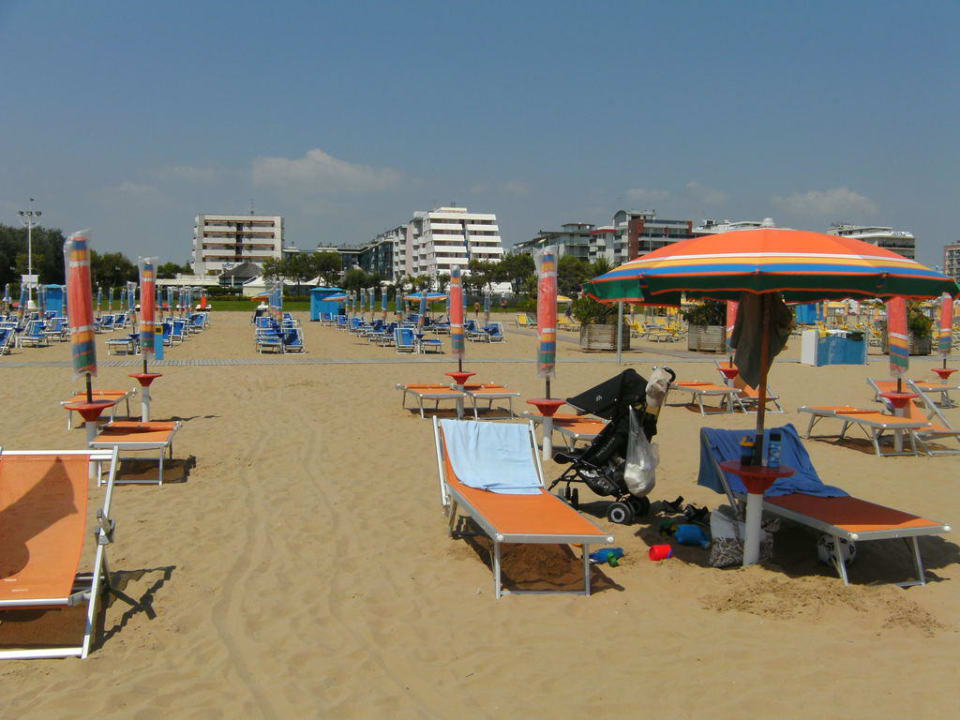 Strand mit Liegen und Hotel hinter in der Mitte Aparthotel Holiday