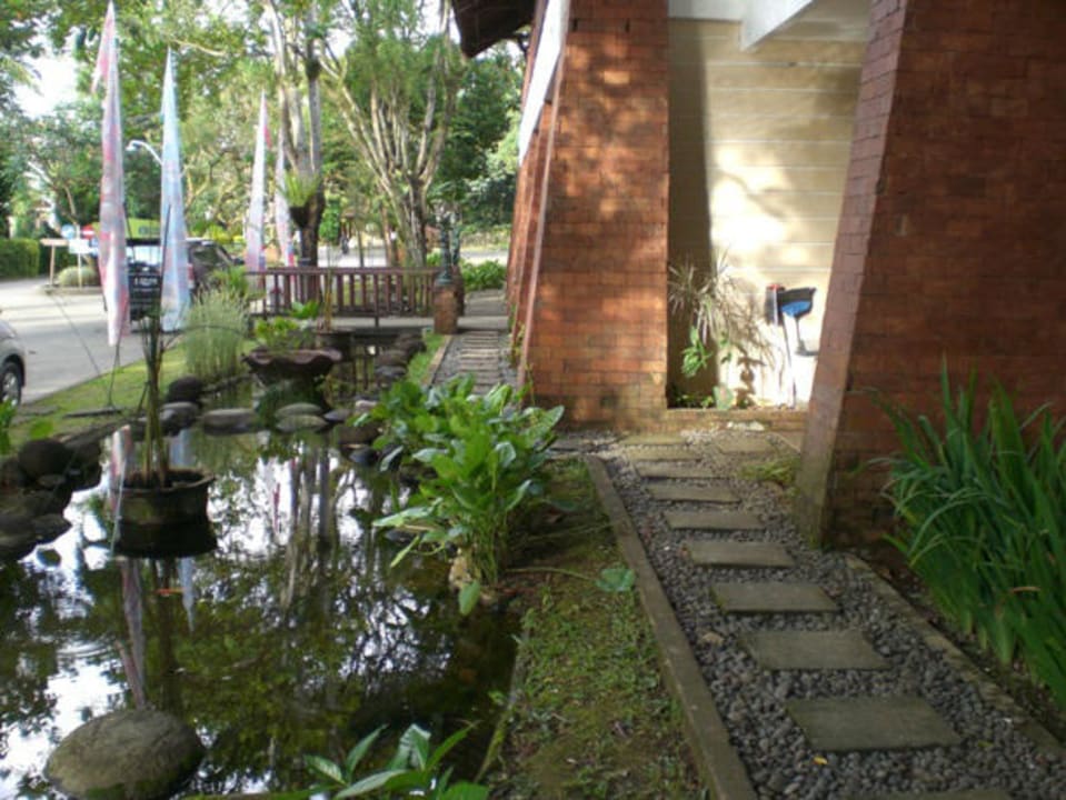 Terrasse mit Teich vor den Standardzimmern Mutiara Carita Cottages