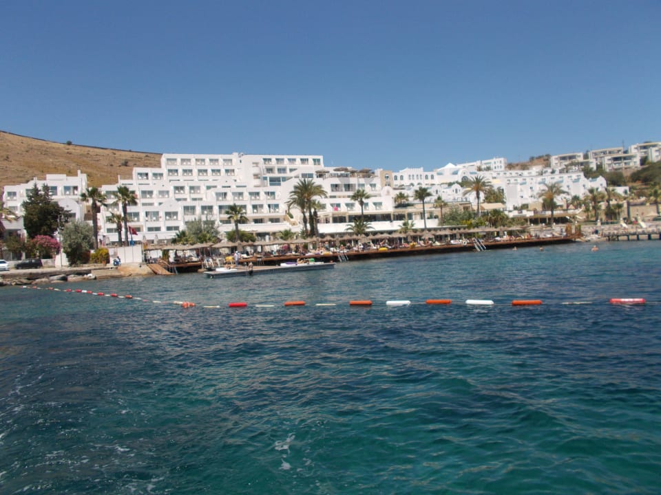 Schönes Hotel mit Strand vom Wasser aus gesehen. Salmakis Resort & Spa