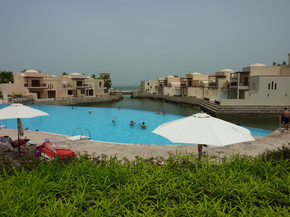 Blick über einen Pool zum Strand  The Cove Rotana Resort