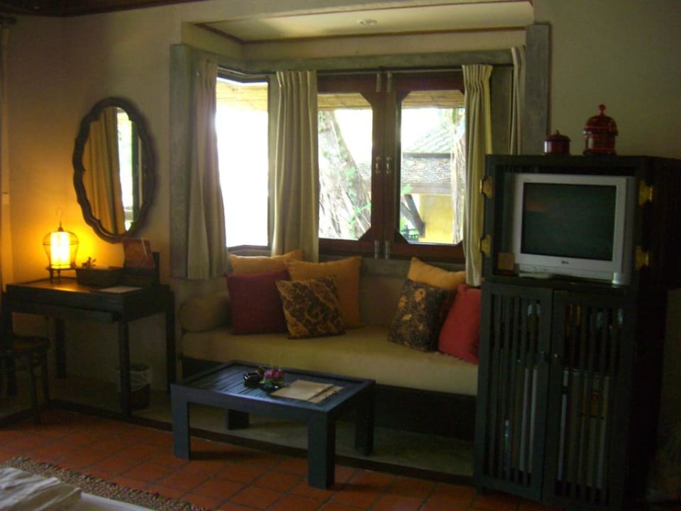 Couch, TV und Schreibtisch im Bungalow Moracea by Khao Lak Resort