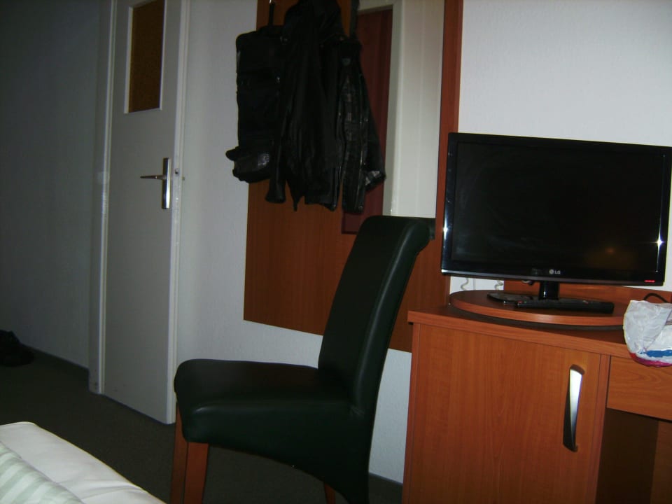 TV auf Minibar, Stuhl, Scheibablage Hotel John Brinckman
