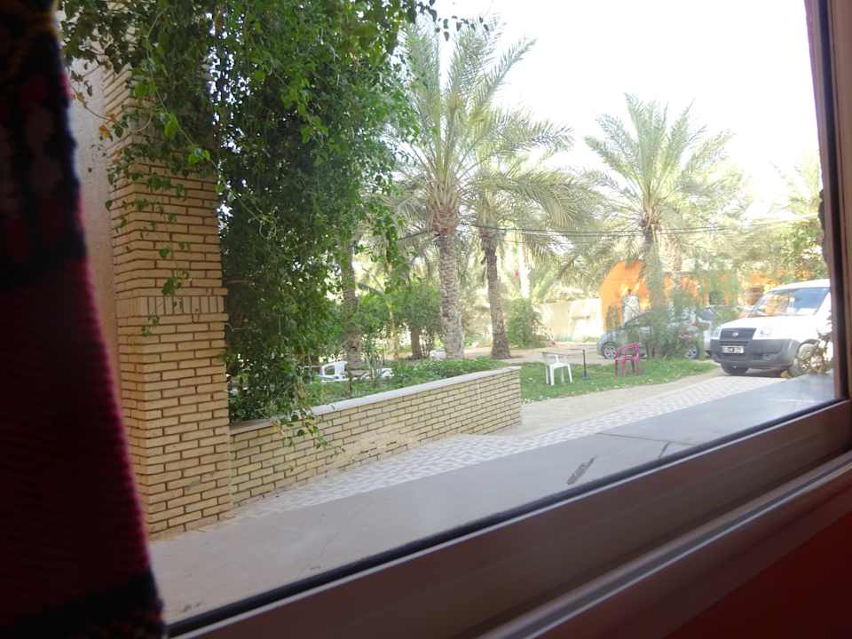 Blick aus dem Frühstücksraum in den Garten und den Parkplatz Hotel Résidence El Arich