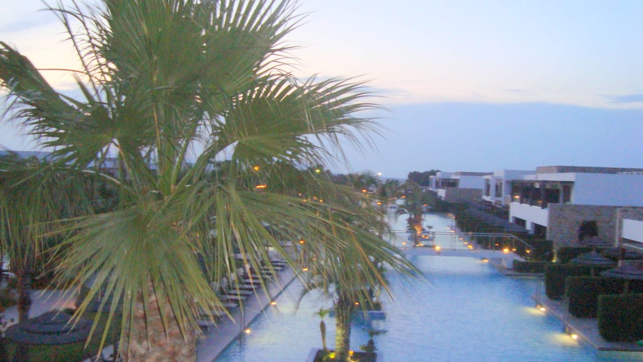 Blick von der Lobby zur Poolanlage bei Dämmerrung  TUI BLUE Palazzo del Mare
