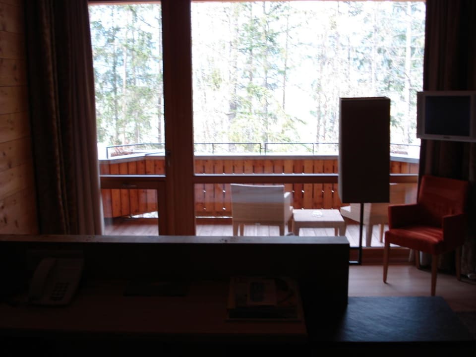 Blick vom Podest übers Bett auf den Balkon Naturhotel Waldklause