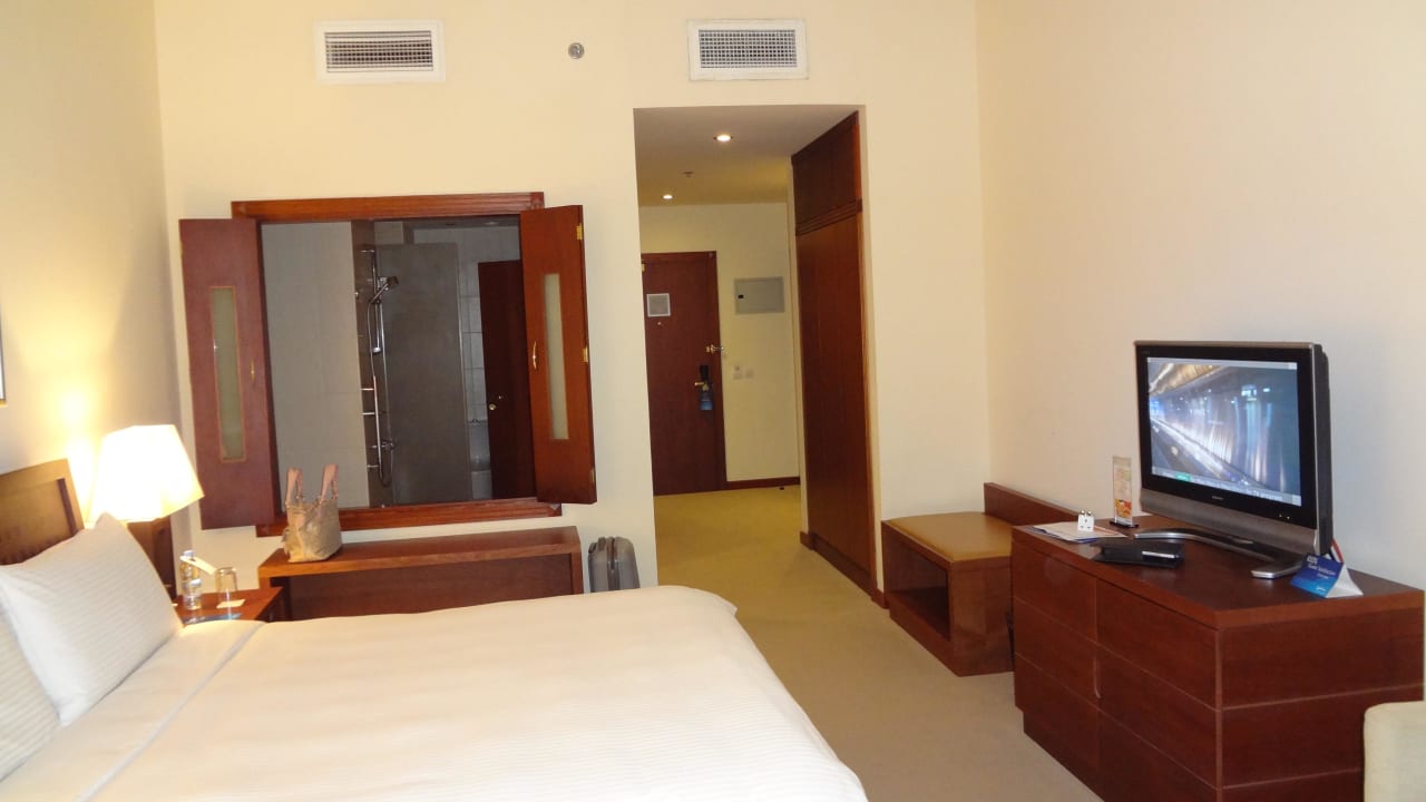 Blick auf Bett, Fernseher, Gang und Bad Radisson Blu Resort Fujairah