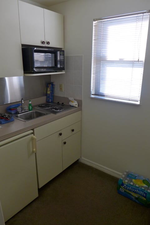 Kleine Küche mit Kühlschrank und Tür Casa Loma Motel on the Waterfront