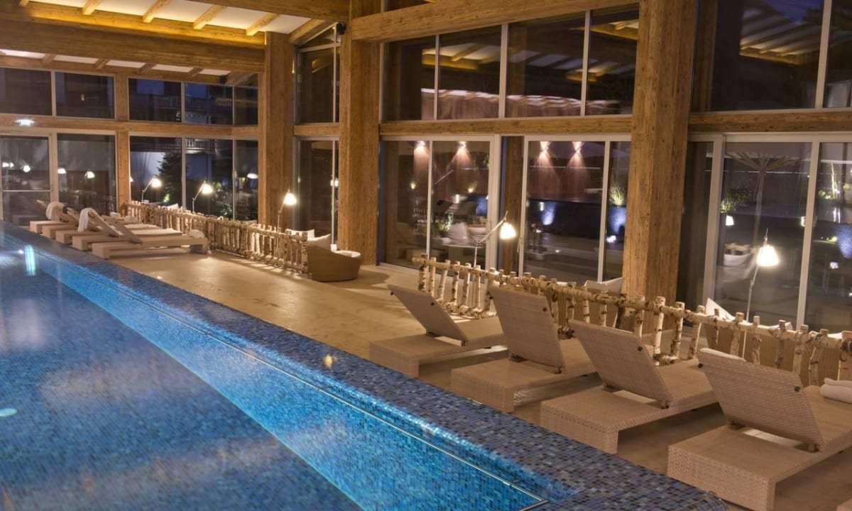 Großer Infinity Pool mit Gartenzugang und Terrasse Das Achental Resort