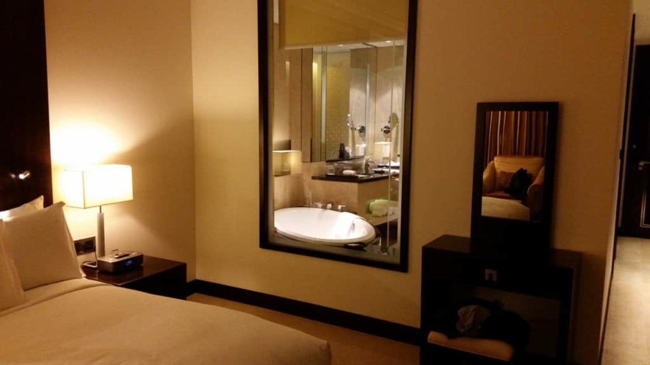 Widok na łazienkę z pokoju przez wewnętrzne okno Conrad Dubai