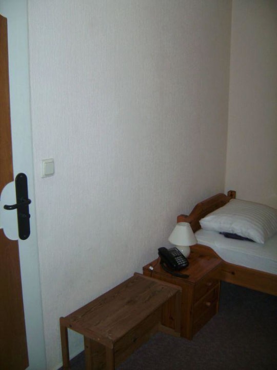 Bett, Nachttisch, Kofferablage und kahle Wände Landhaus Ohlstedt
