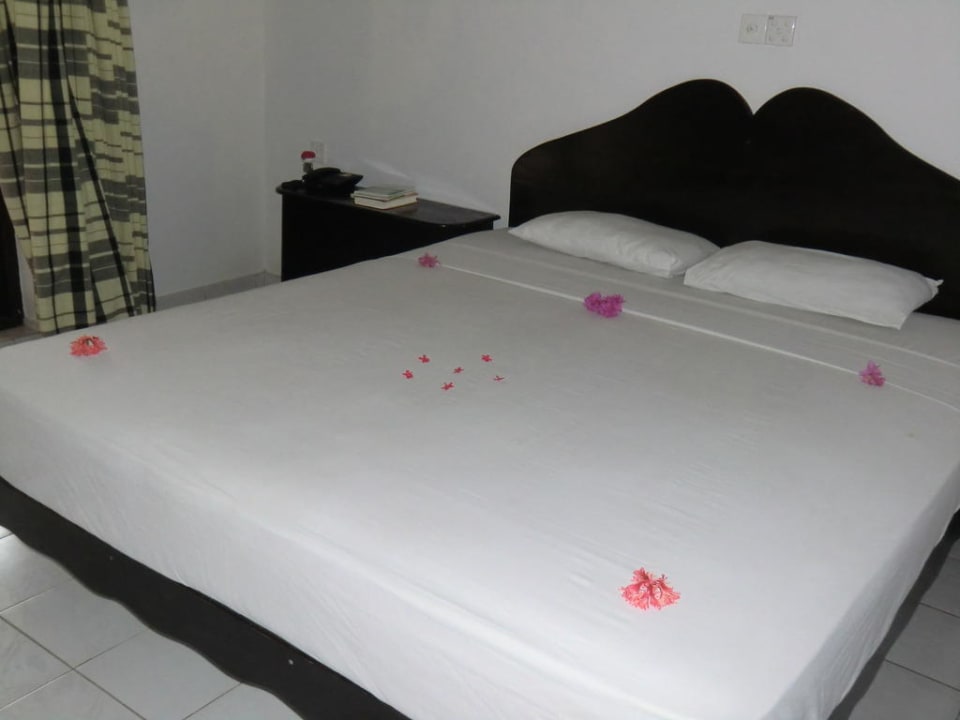 Bett mit Blumen-Deko Wunderbar Beach Club Hotel