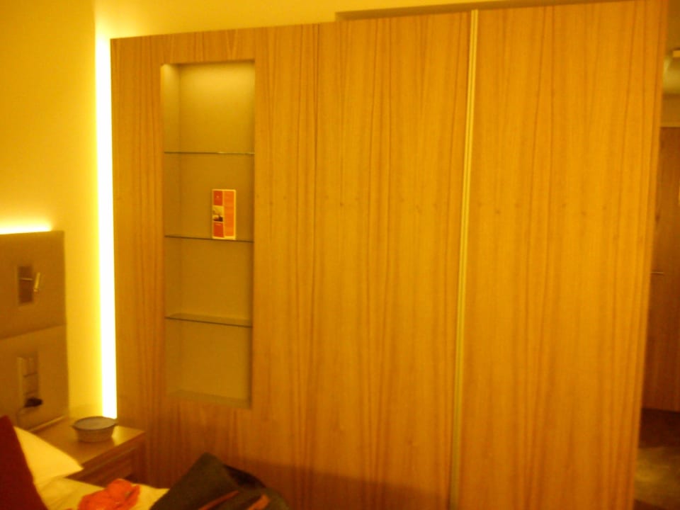 Schrank neben dem Bett H4 Hotel München Messe