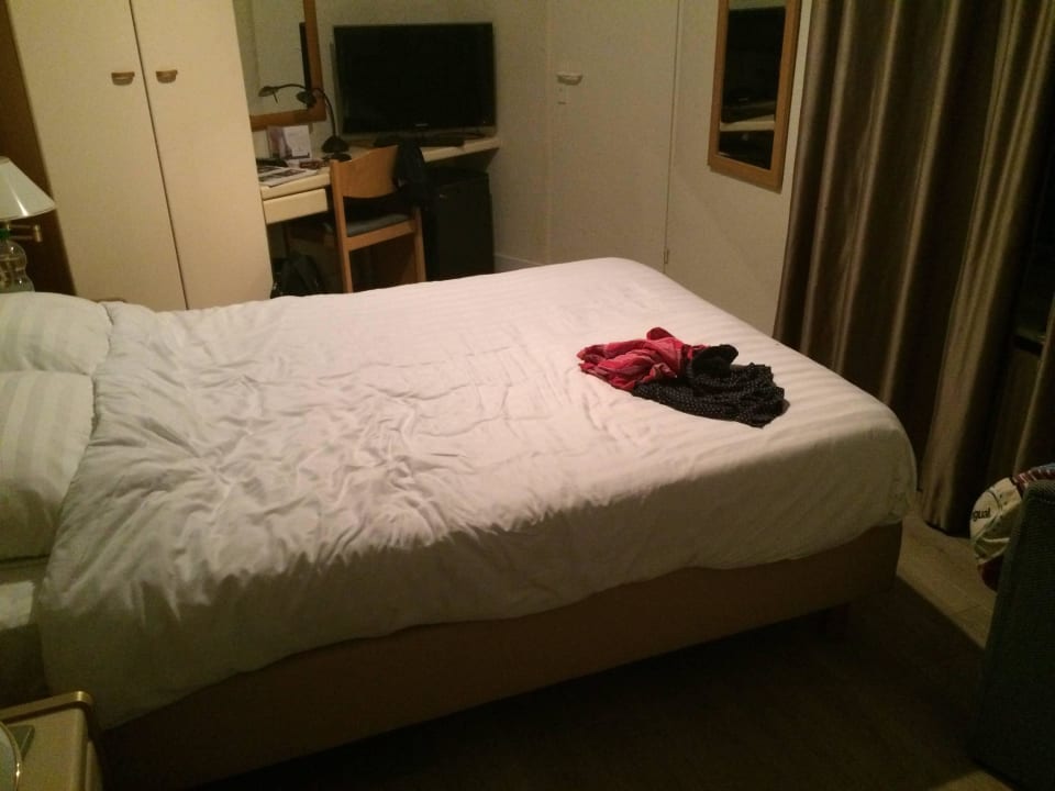 Bett mit Schrank, Schreibtisch & TV im Hintergrund Hotel Tulip Inn Bergen op Zoom