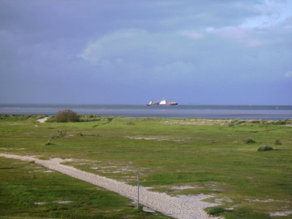 Deichblick: zu Sandstrand, hinten schwach: Roter Sand Upstalsboom Hotel am Strand