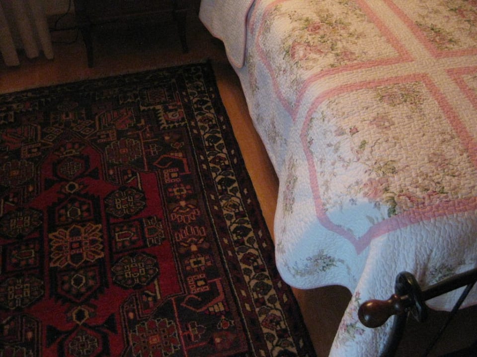 Blick auf Bett und Teppich Hotel Villa Busta