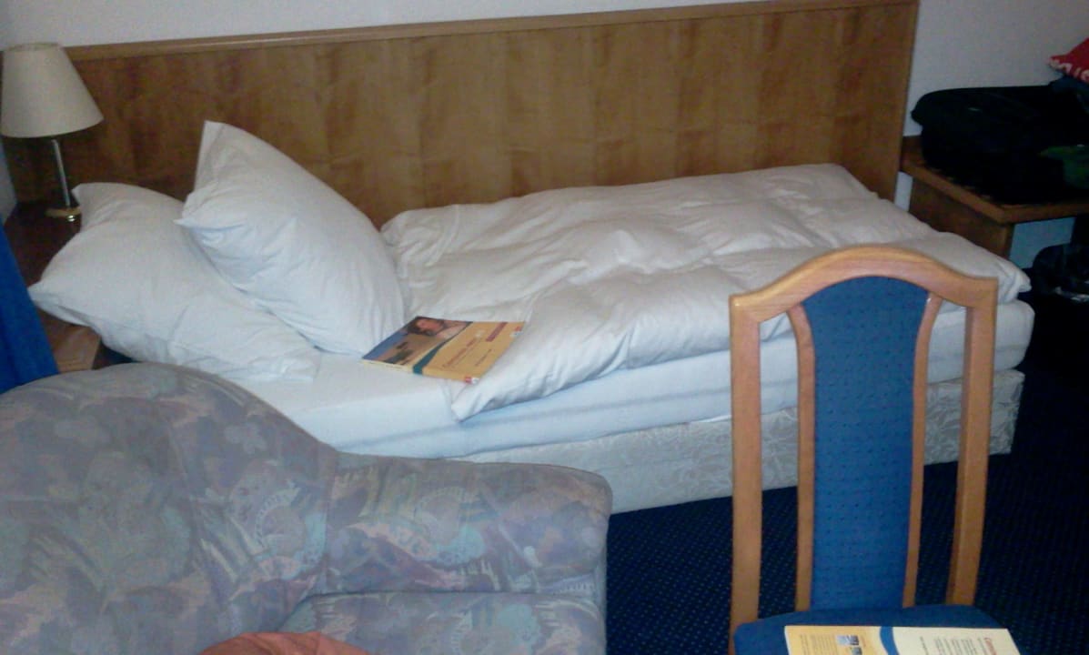 Blick auf Bett, Sessel und Stuhl Hotel Wester