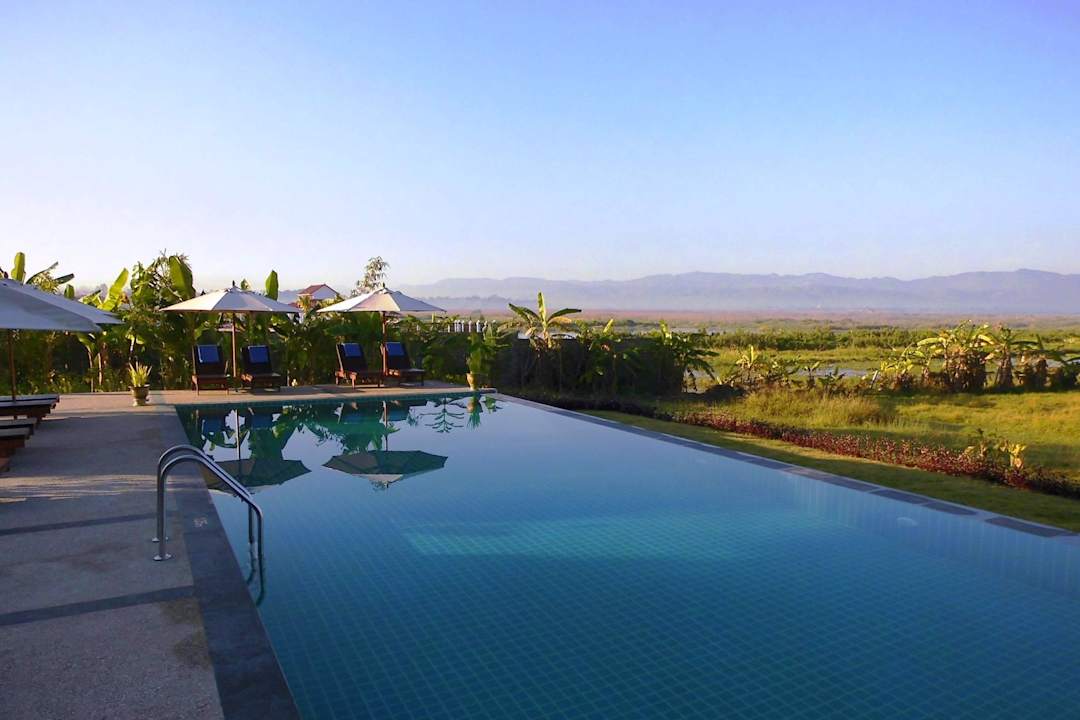 Schöner großer Pool mit Blick auf den See. Amata Garden Resort