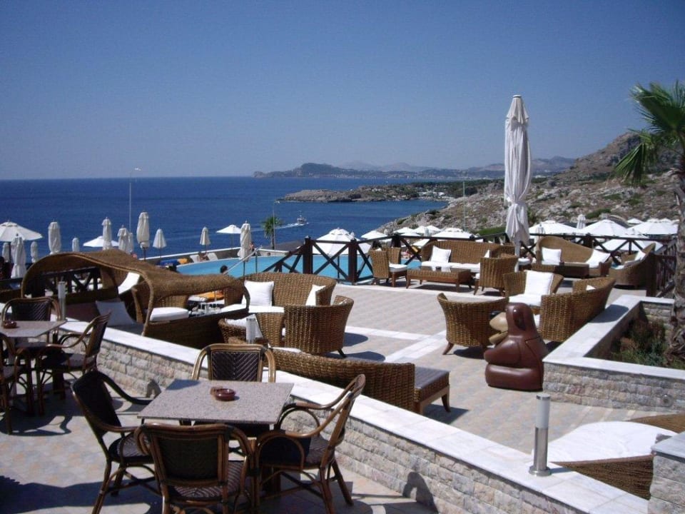 Sitzmöglichkeiten am Pool tagsüber und Abends Hotel Kalithea Horizon Royal