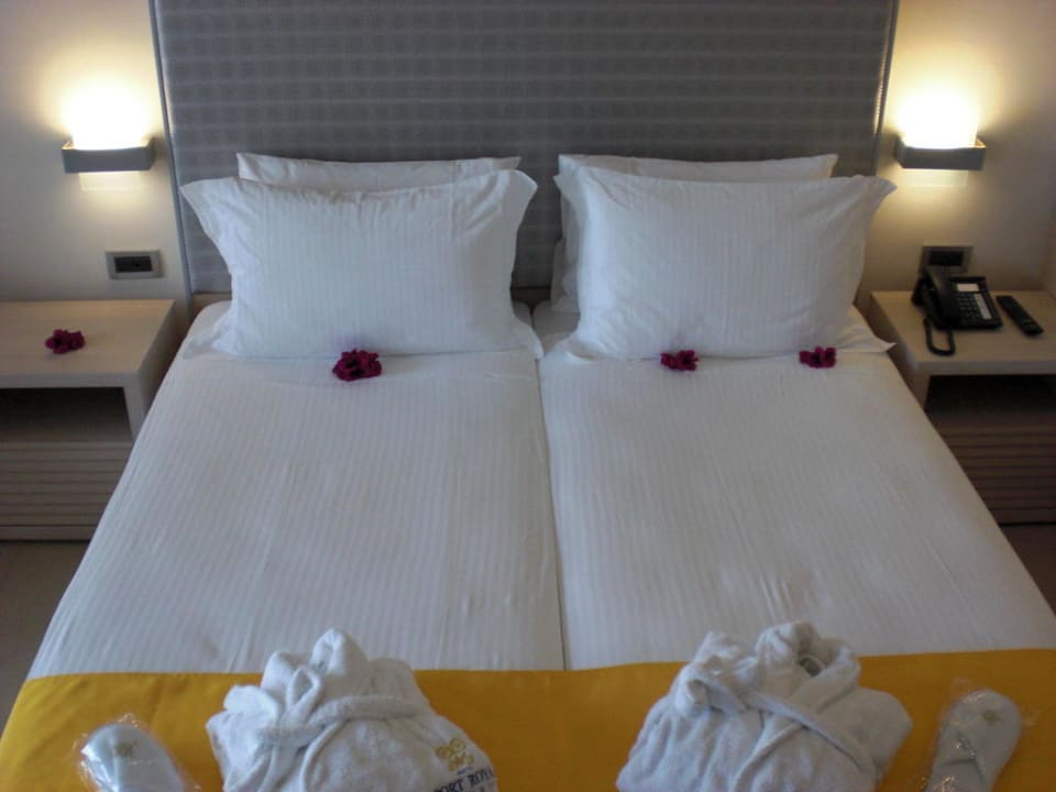 Bett mit Bademantel uns Latschen SENTIDO Port Royal Villas & Spa