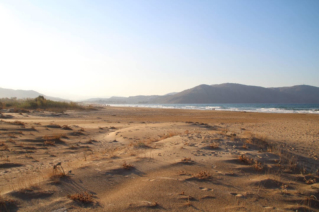 Schöner breiter Sandstrand mit ein paar Steinen. HARPIN Georgioupolis Resort Aquapark & SPA