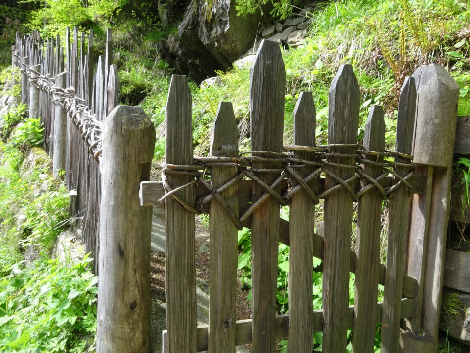 Verflochtener Holzzaun am Weg zum Longfall Hotel Lisetta