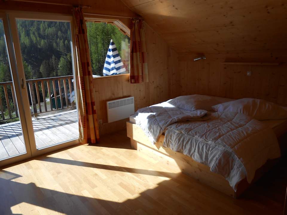 Großes Zimmer mit Doppelbett und Couch MarktlAlm Almhüttendorf Turracher Höhe