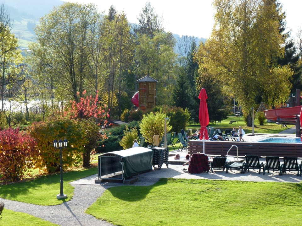 Blick von der Terrasse auf den Pool und Garten Hotel Bellevue am See