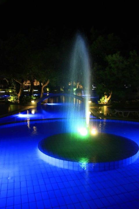 Pool mit Springbrunnen bei Nacht Hotel Kalithea Mare Palace