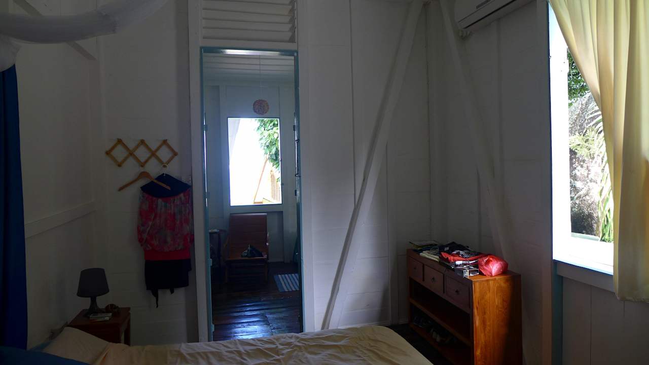 Schlafzimmer mit Tür zum Einzelbett und Eingang Guesthouse The Beach House