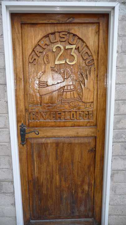Die geschnitzte Eingangstür Sarasungu River Lodge