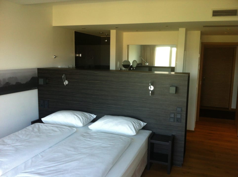 Doppelbett, dahinter Nasszelle Hotel Burghof DAS HOTEL