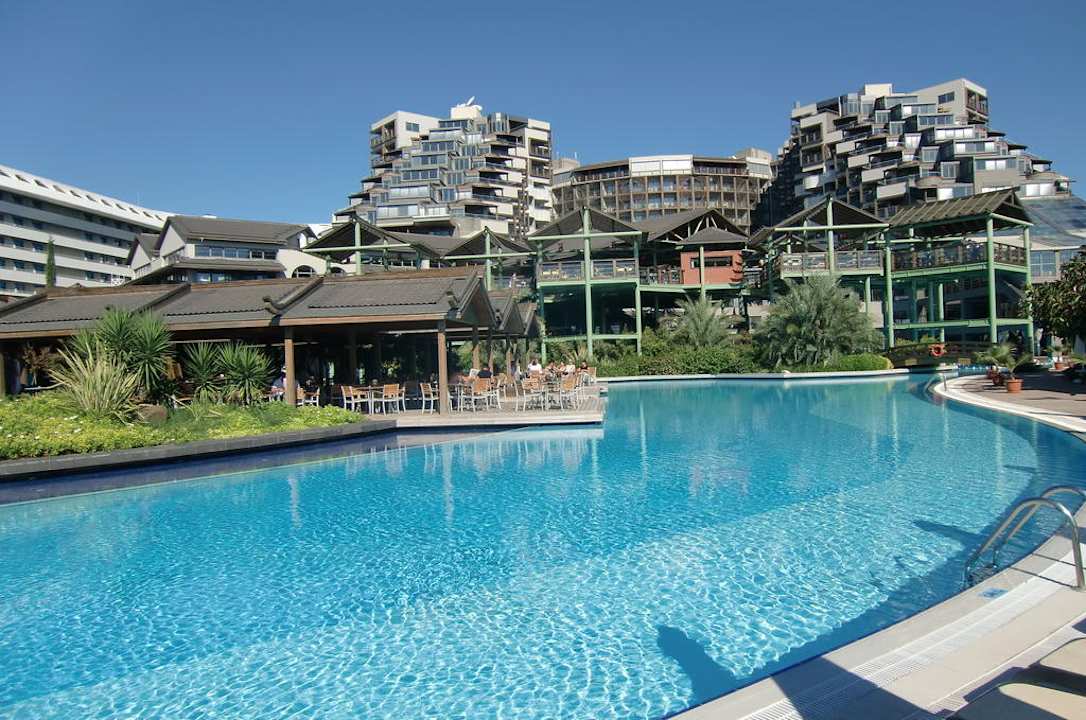 Teil der Poolanlage mit Hotel im Hintergrund Limak Lara Deluxe Hotel & Resort