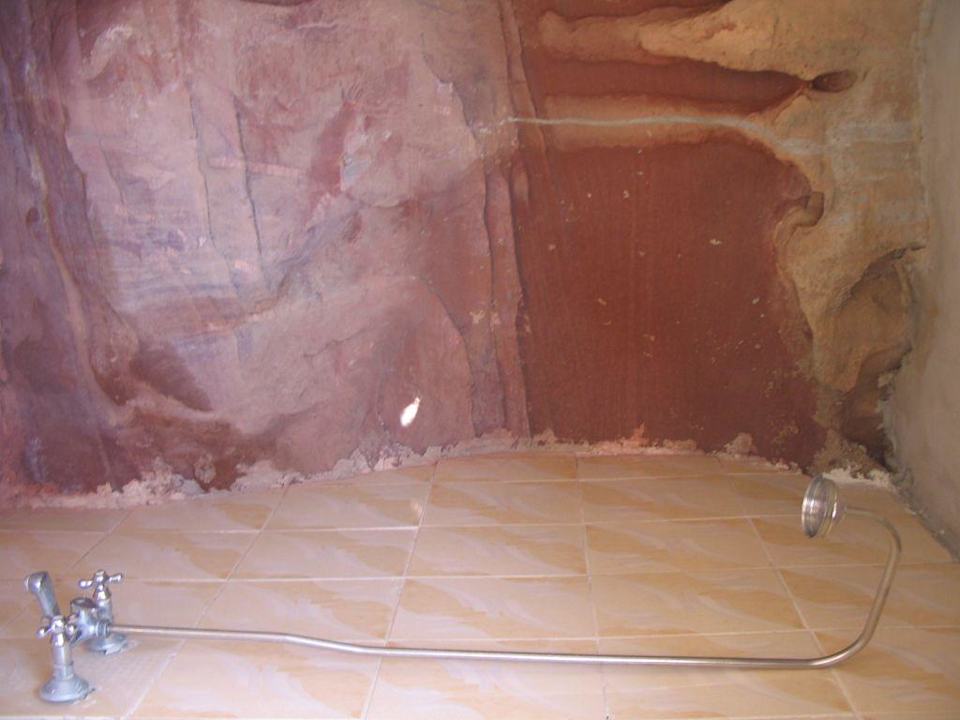 Shared shower with rocky walls Oasis Desert Camp