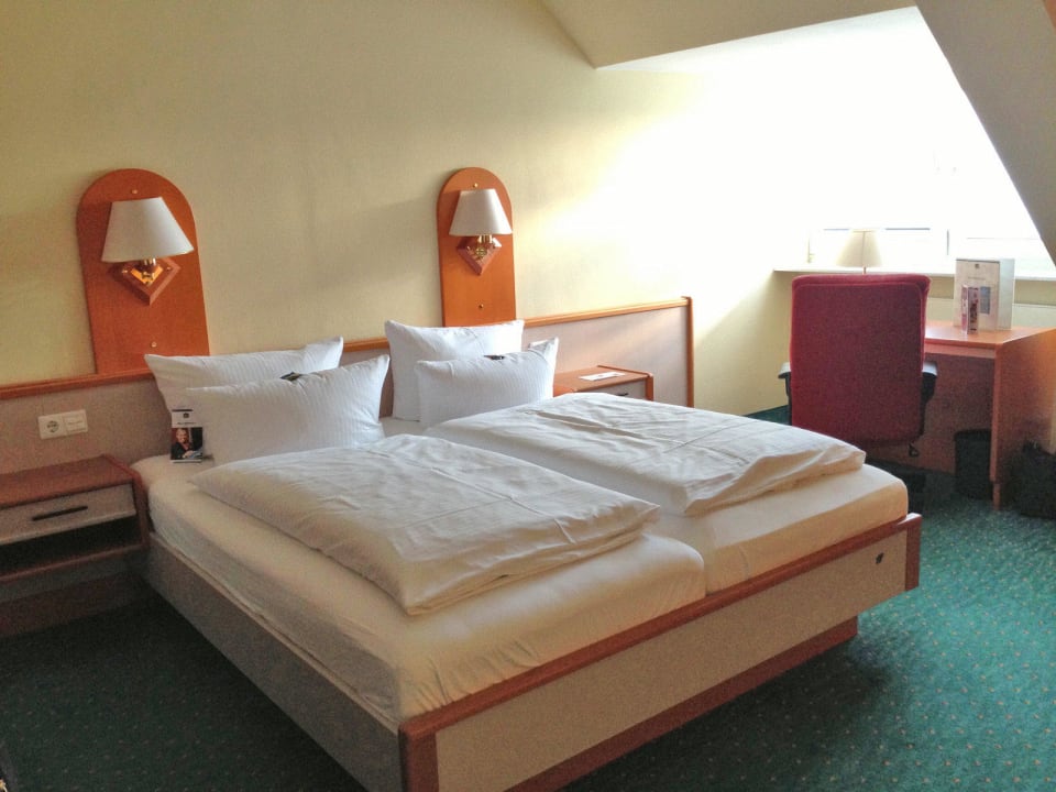 Blick auf Bett & Schreibtisch Hotel DER LINDENHOF