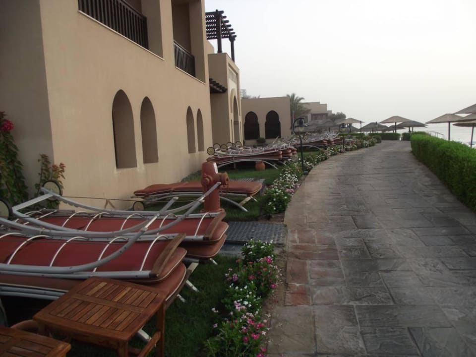 Liegen werden wegen Sturm vom Strand gesichert Miramar Al Aqah Beach Resort
