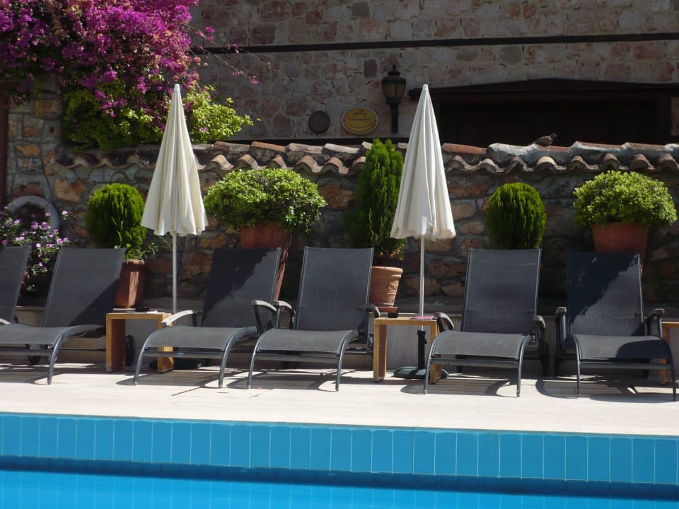 Blick von einer Liege auf die andere Seite d Pools Tuvana Hotel