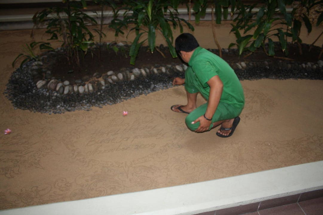 Hotelangestellter beim malen im Sand Paradisus by Melia Bali