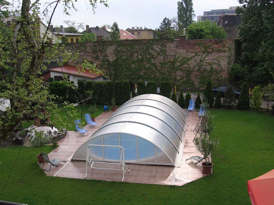 Pohled z okna na zahradu se zavřeným bazénem Hotel Manzard