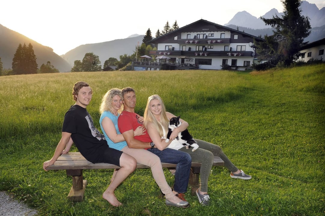 Gastgeberfamilie mit Hotel im Hintergrund Kraftplatz am Dachstein - BioHotel Herold