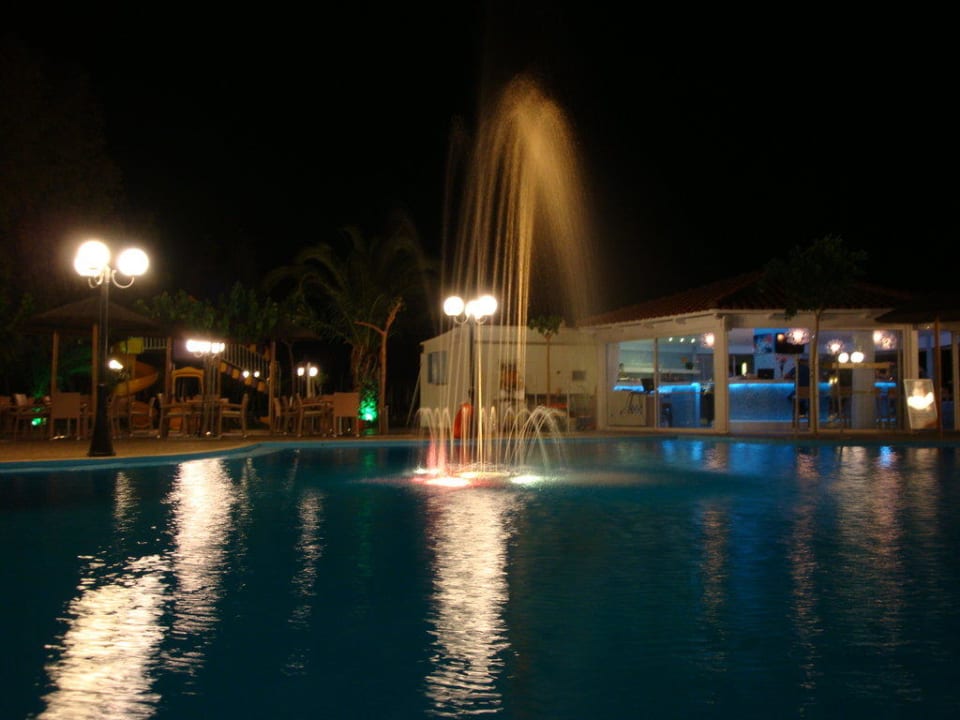 Blick über den Pool zur Bar bei Nacht Hotel Corissia Princess