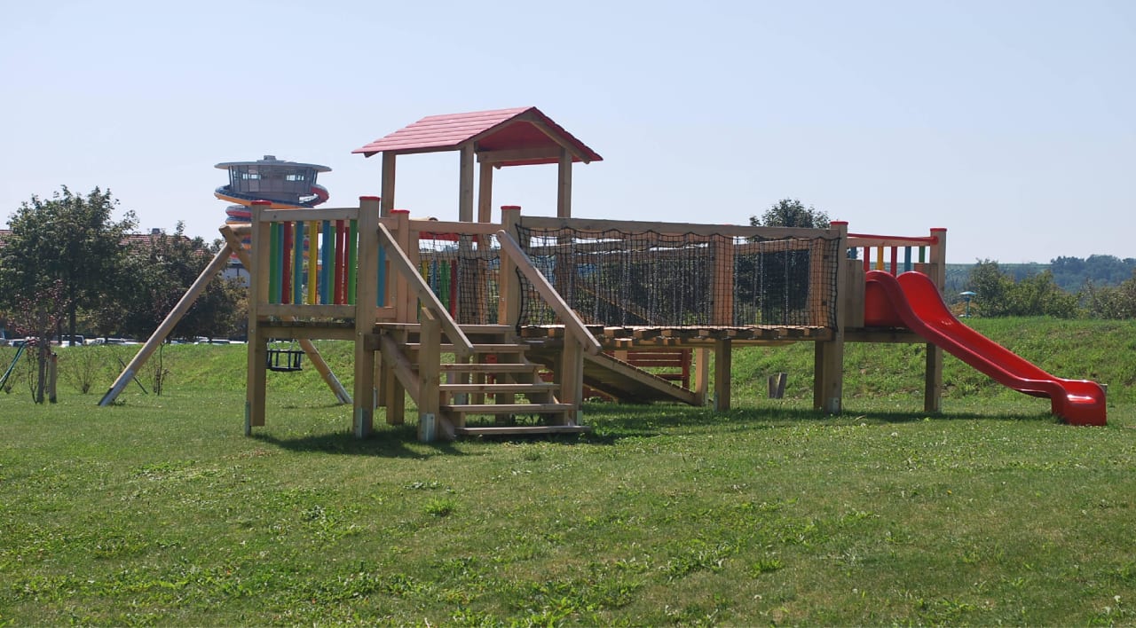 Blick vom Kinderspielplatz auf die Sonnentherme All In Red Thermenhotel